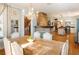 Open-concept dining room featuring a chandelier, hardwood floors, white walls, and a brick fireplace at 527 Main St, Suwanee, GA 30024
