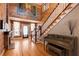 Grand foyer with beautiful wood floors, staircase, and a grand painting on the wall at 527 Main St, Suwanee, GA 30024