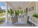 Spacious front porch features wicker seating, ceiling fan and decorative rug at 527 Main St, Suwanee, GA 30024