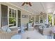 Covered front porch with wicker furniture and ceiling fan overlooking the yard at 527 Main St, Suwanee, GA 30024
