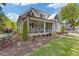 Charming gray home with a covered front porch, manicured lawn, and beautiful landscaping at 527 Main St, Suwanee, GA 30024