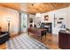 Inviting home office featuring a wood ceiling, classic desk, fireplace, and built-in bookshelves at 527 Main St, Suwanee, GA 30024