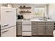 Bright and stylish kitchen with stainless steel sink, painted cabinets and floating shelves at 527 Main St, Suwanee, GA 30024