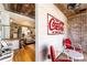Living room view with original hardwood floors, brick accents, and a Coca-Cola themed seating area at 527 Main St, Suwanee, GA 30024