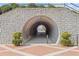 Unique stone tunnel entrance with brick accents, inviting visitors to explore the path beyond at 527 Main St, Suwanee, GA 30024