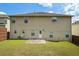 The property has a large backyard with a small concrete patio, grass, and beige two-story house at 7328 Vigo Dr, Lithonia, GA 30058
