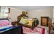 A bedroom featuring a bed with yellow floral sheets, ornate wood frame and patterned rug at 7328 Vigo Dr, Lithonia, GA 30058