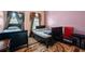 Bedroom with two beds, neutral carpet, dark wood trim, windows with curtains and a red chair at 7328 Vigo Dr, Lithonia, GA 30058