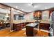 Open-concept kitchen with stainless steel appliances, granite countertops, and cherry cabinets next to the dining room at 7328 Vigo Dr, Lithonia, GA 30058