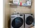 A laundry room with a wire shelf, laundry supplies and modern Samsung washer and dryer appliances at 7328 Vigo Dr, Lithonia, GA 30058