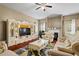 Inviting living room featuring a decorative fireplace, white furniture, and views to backyard trees at 7328 Vigo Dr, Lithonia, GA 30058