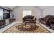 Formal living room with dark wood furniture, decorative area rug, and a large window with neutral curtains at 7328 Vigo Dr, Lithonia, GA 30058