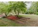 Expansive backyard with manicured lawn, bordered by trees and landscaping, great for outdoor activities at 8315 Nicholson Rd, Cumming, GA 30028
