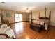 Spacious bedroom with four-poster bed, hardwood floors, and large windows at 8315 Nicholson Rd, Cumming, GA 30028