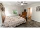 Cozy bedroom features floral bedding, a ceiling fan, a window, and an adjacent entryway at 8315 Nicholson Rd, Cumming, GA 30028