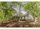 Quaint home set amongst mature trees featuring a charming, covered front porch, ideal for outdoor relaxation at 8315 Nicholson Rd, Cumming, GA 30028