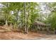 Charming home nestled in mature trees featuring a spacious covered porch, creating a peaceful retreat at 8315 Nicholson Rd, Cumming, GA 30028