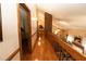Hallway with view overlooking the living room with vaulted ceiling and exposed brick at 8315 Nicholson Rd, Cumming, GA 30028
