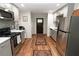 Modern kitchen with stainless steel appliances, granite countertops, tiled backsplash, and hardwood flooring at 8315 Nicholson Rd, Cumming, GA 30028