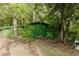 A spacious green outbuilding nestled in a wooded area, perfect for storage or a hobby space surrounded by nature at 8315 Nicholson Rd, Cumming, GA 30028