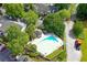 Aerial view showcases the community pool nestled among mature trees and lush landscaping at 105 Olde Mill Ln, Norcross, GA 30093