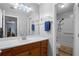 Bathroom featuring vanity with updated sink, large mirror, lighting, and walk-in shower and tub at 105 Olde Mill Ln, Norcross, GA 30093