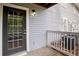 Back entrance showing black framed door and porch area with gray siding and white railing at 105 Olde Mill Ln, Norcross, GA 30093