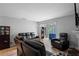 Bright living room featuring plush black couches, wood flooring, and a fireplace at 105 Olde Mill Ln, Norcross, GA 30093