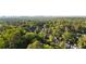 Picturesque aerial view of the lush neighborhood showcasing beautiful homes amidst verdant trees, with the city skyline in the distance at 1201 Beech Valley Ne Rd, Atlanta, GA 30306