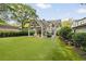 Exterior view features a backyard with a covered patio, outdoor seating, and a manicured lawn with landscaping at 1201 Beech Valley Ne Rd, Atlanta, GA 30306