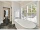 Modern bathroom featuring a freestanding tub, herringbone tile floor, and bright window light at 1201 Beech Valley Ne Rd, Atlanta, GA 30306