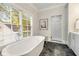 Bright bathroom with a freestanding tub, herringbone tile floor, and walk-in shower at 1201 Beech Valley Ne Rd, Atlanta, GA 30306
