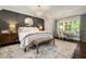 Well-lit bedroom with paneled accent wall, a large rug, and a bench at the foot of the bed at 1201 Beech Valley Ne Rd, Atlanta, GA 30306