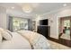 Bright bedroom featuring a large window, sizable dresser with TV, and doorway to the bathroom at 1201 Beech Valley Ne Rd, Atlanta, GA 30306