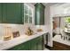 Olive cabinets, white countertops and subway tile in the butler's pantry at 1201 Beech Valley Ne Rd, Atlanta, GA 30306
