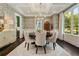 Chic dining room with stylish chandelier, beautiful wallpaper, large windows, and a round wooden table set for six at 1201 Beech Valley Ne Rd, Atlanta, GA 30306