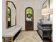 Inviting foyer featuring dark wood flooring, arched door, a vintage mirror, and stylish console table with lamp at 1201 Beech Valley Ne Rd, Atlanta, GA 30306