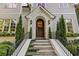 Welcoming front door with classic arch, decorated with a wreath, framed by two matching evergreen topiaries at 1201 Beech Valley Ne Rd, Atlanta, GA 30306