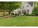 Beautiful home featuring a lush green lawn, mature tree, manicured landscaping, and a charming gray exterior at 1201 Beech Valley Ne Rd, Atlanta, GA 30306