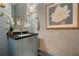 Stylish powder room featuring elegant blue wallpaper, a modern vanity, gold fixtures, and decorative artwork at 1201 Beech Valley Ne Rd, Atlanta, GA 30306