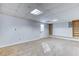 Spacious unfinished basement featuring tile ceilings and walkout door at 1355 Compton Woods Dr, Loganville, GA 30052