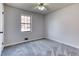 Cozy bedroom featuring plush grey carpeting, a ceiling fan, and a bright window at 1355 Compton Woods Dr, Loganville, GA 30052