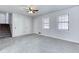 Bright living room with neutral carpeting, a ceiling fan, and staircase access at 1355 Compton Woods Dr, Loganville, GA 30052