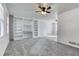 Spacious living room featuring built-in shelving, a ceiling fan, and neutral-toned carpeting at 1355 Compton Woods Dr, Loganville, GA 30052