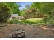 View of the home's lush, private backyard with fire pit area and mature trees at 2129 Arlington Ne Ave, Atlanta, GA 30324