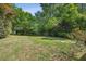Serene and shaded backyard with a lush green lawn, mature trees, and privacy fence at 2129 Arlington Ne Ave, Atlanta, GA 30324