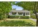 Charming single-story home with a well-manicured lawn, lush greenery, and painted white brick at 2129 Arlington Ne Ave, Atlanta, GA 30324