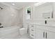 Modern bathroom featuring a shower-tub combo, window, and a white vanity with black hardware at 2977 N Bogan Rd, Buford, GA 30519