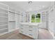 This walk-in closet boasts custom shelves and cabinets surrounding a center island with drawers at 2977 N Bogan Rd, Buford, GA 30519