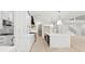 Bright kitchen with large island, stainless steel appliances, designer cabinets and open floor plan leading to stairs at 2977 N Bogan Rd, Buford, GA 30519